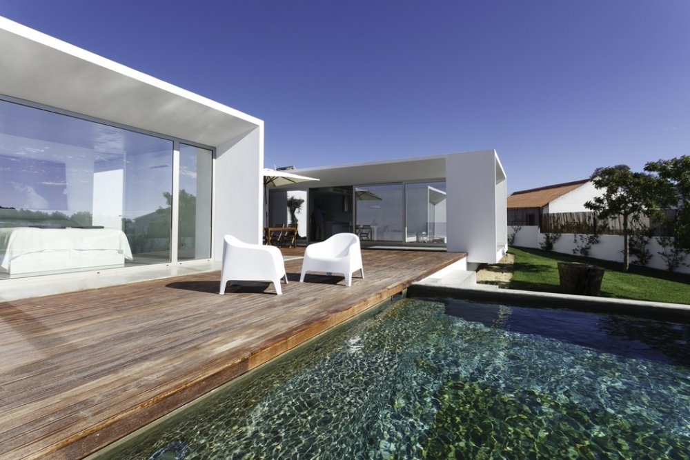 "casa moderna in xlam, una casa in bioedilizia, con ampia vetrata, deck in legno e piscina, realizzata tra Milano e Varese.