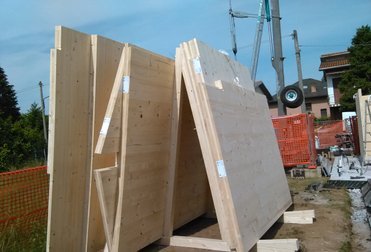 Pannelli in legno massiccio a strati incrociati pronti per il montaggio e dettaglio di una struttura portante in X-Lam.