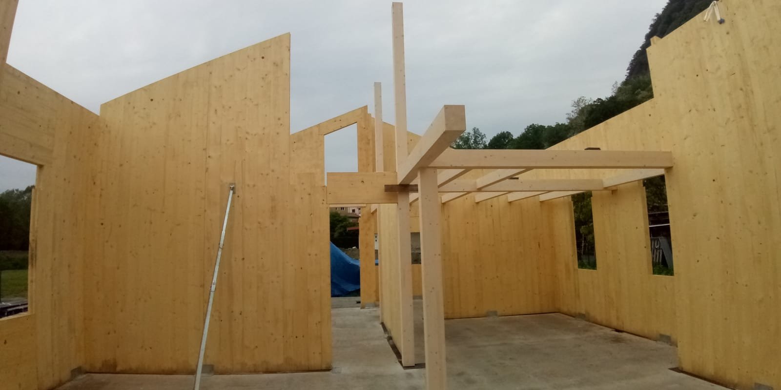 Cantiere di un edificio residenziale in legno con pareti strutturali in X-Lam e orditura del solaio in travi lamellari.
